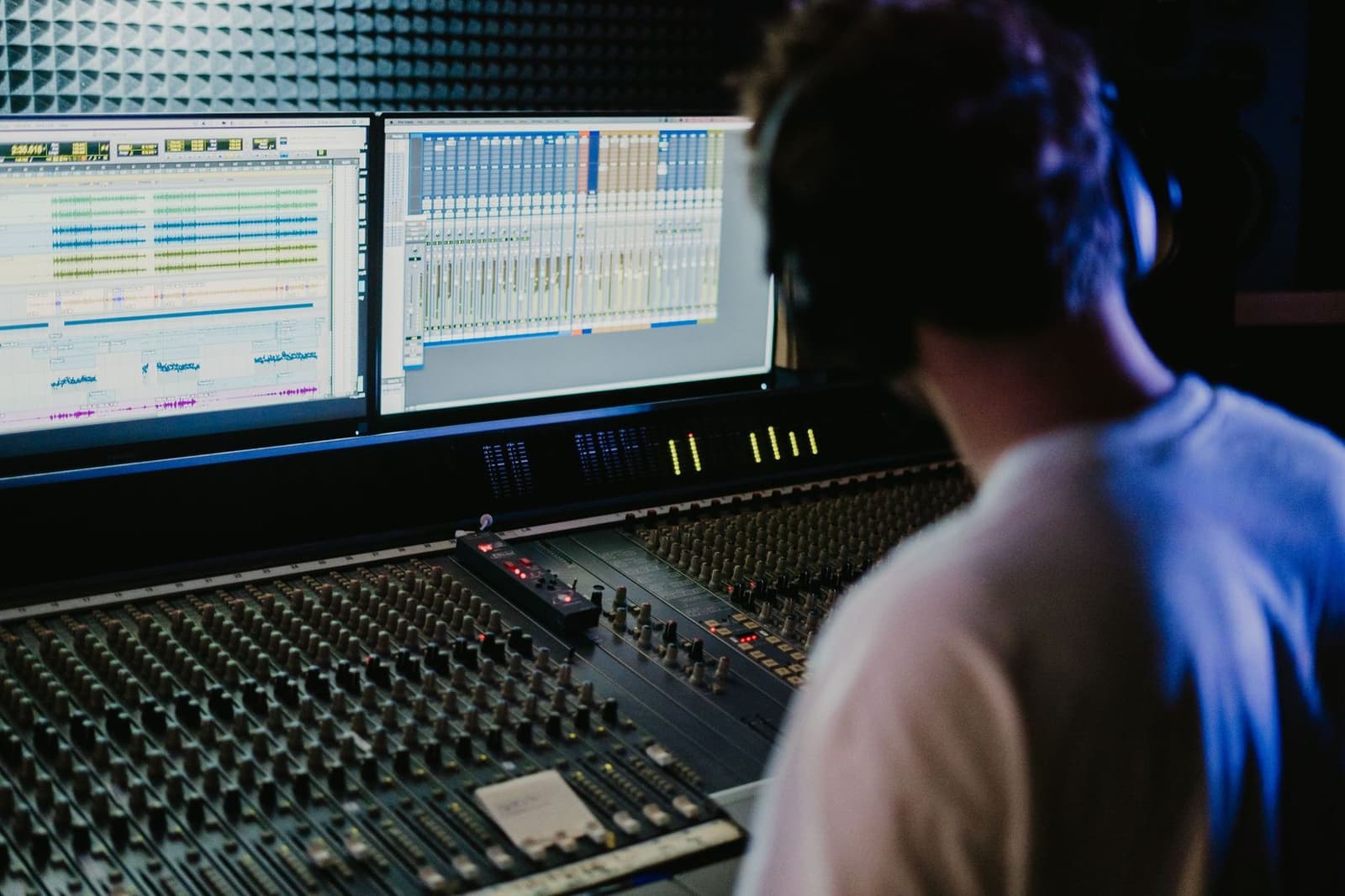 A producer working at a mixing desk in a recording studio
